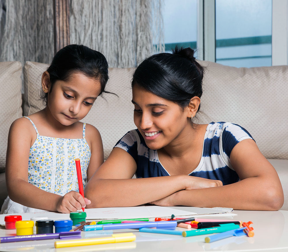 Girl colouring with her mother